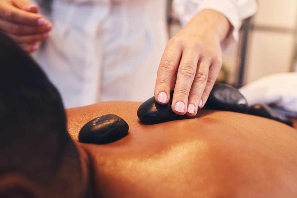 hands hot stone and massage with a man in a spa 2023 11 27 05 13 36 utc